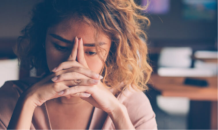 Woman with hands to face experiencing ADHD burnout