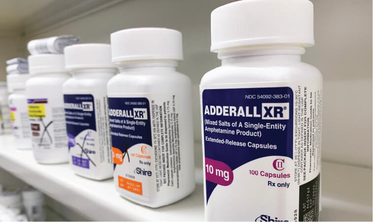 Image of Adderall XR bottle on store shelf to symbolize Focalin vs Adderall.