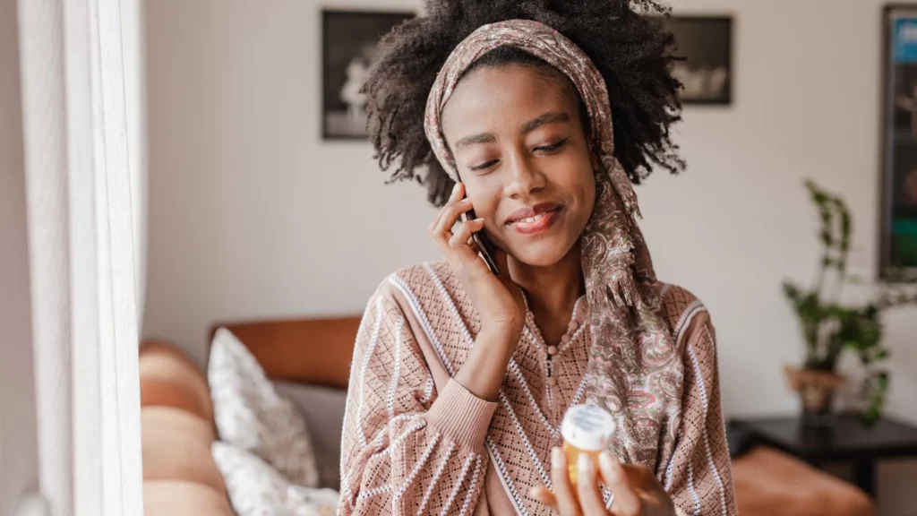 The woman reading the bottle of pills and talking with her doctor